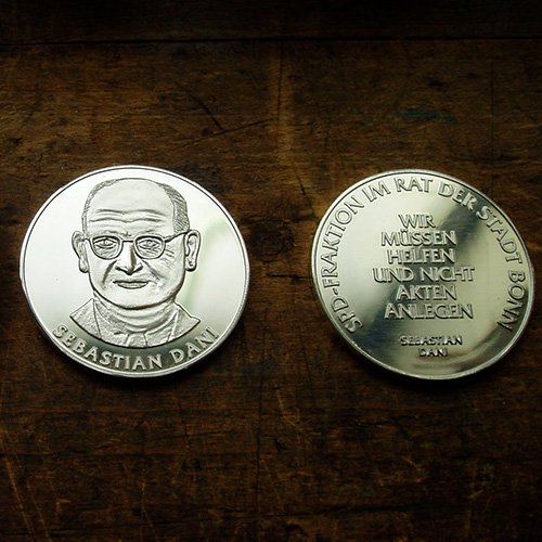 Eine Medaille aus Silber von beiden Seiten.